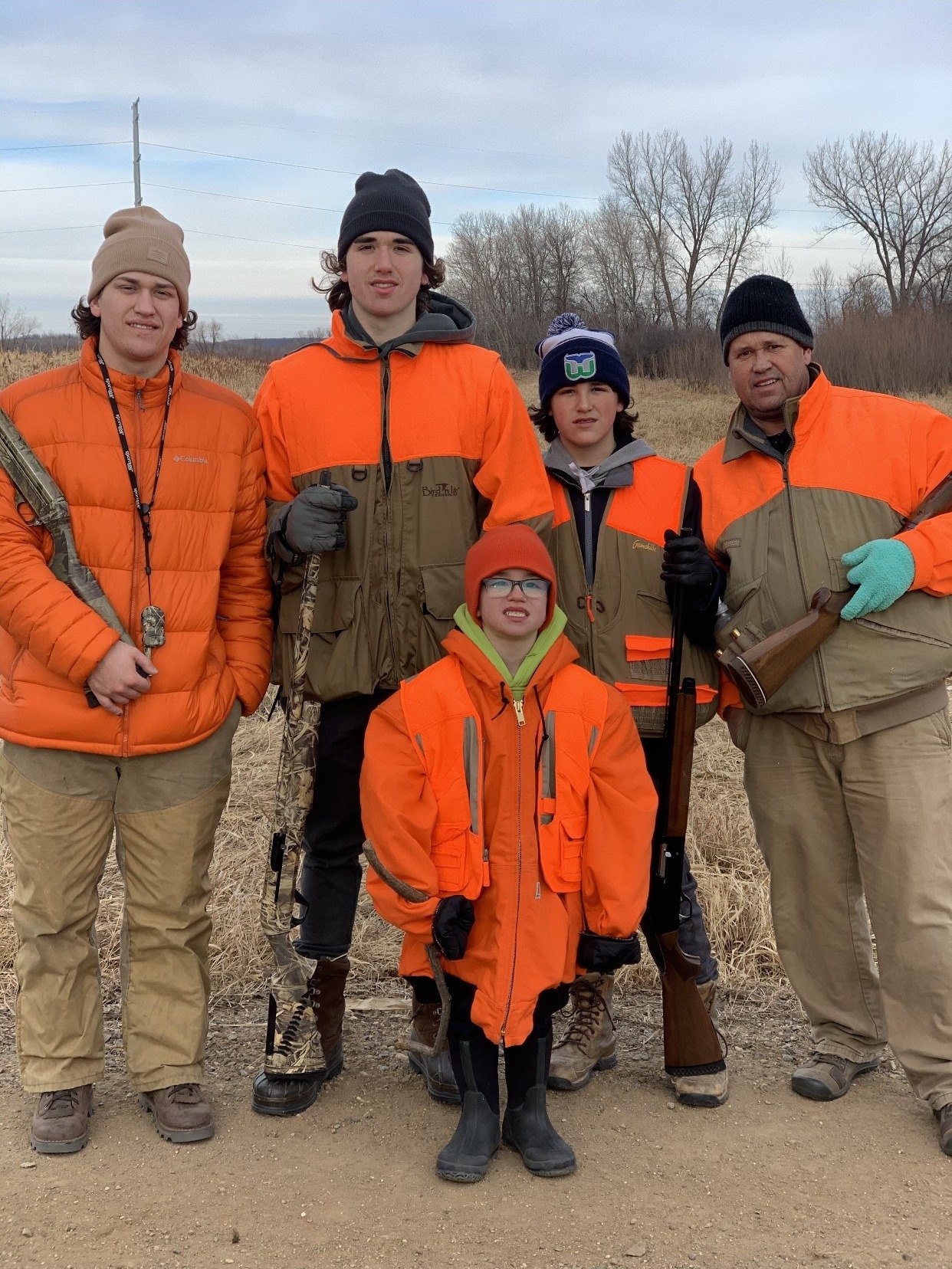 A family in blaze orange after a pheasant hunt