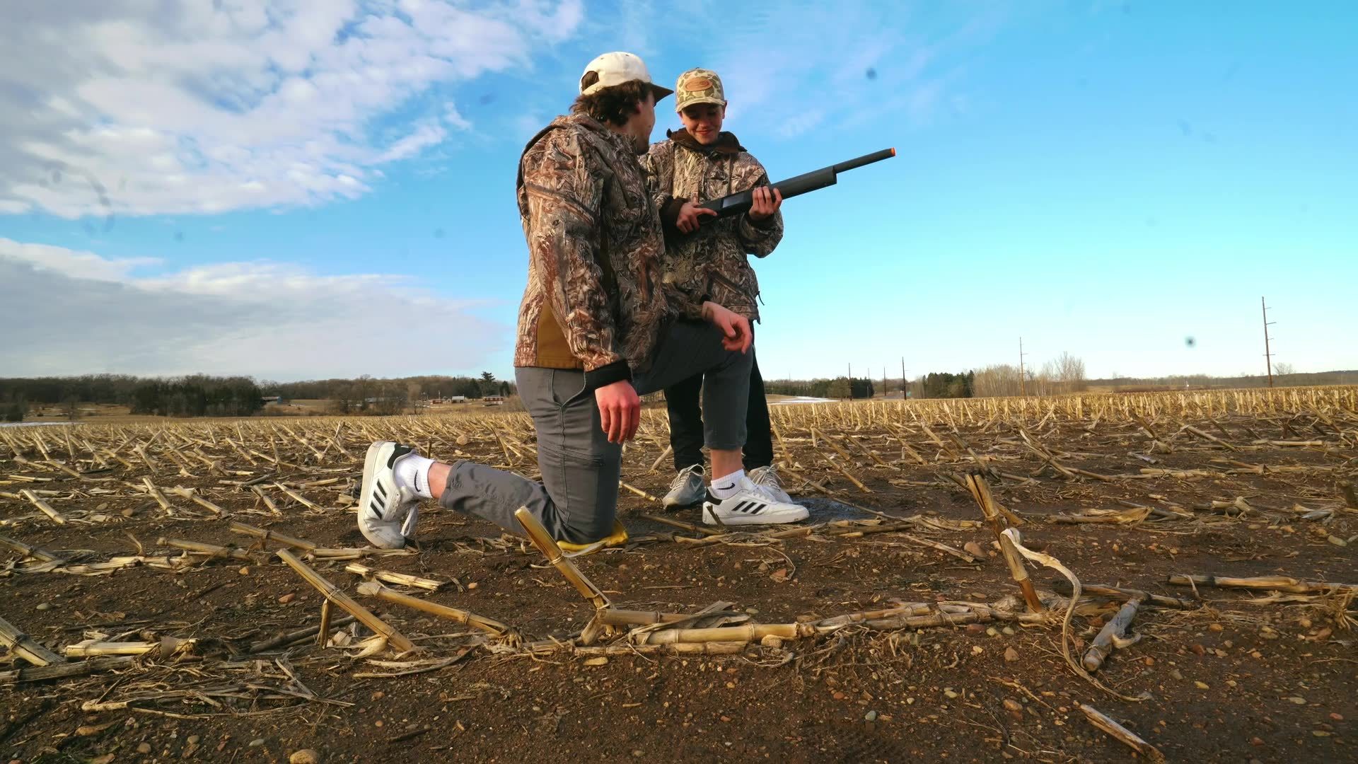 A coach guiding a young hunter through safe practice in a field