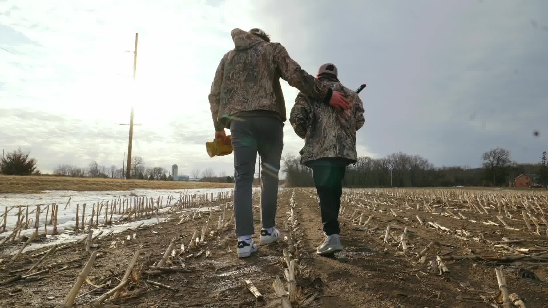 A coach and young hunter walking into a Minnesota field